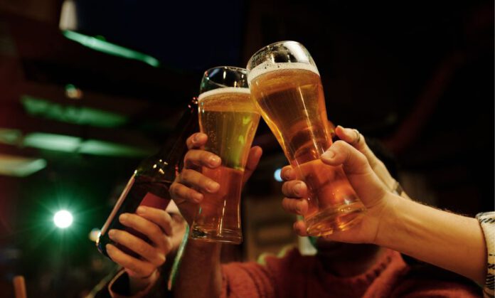 בתמונה, צילום להמחשה של פסטיבל הבירה בנתניה - אנשים מחזיקים כוסות בירה בכיכר