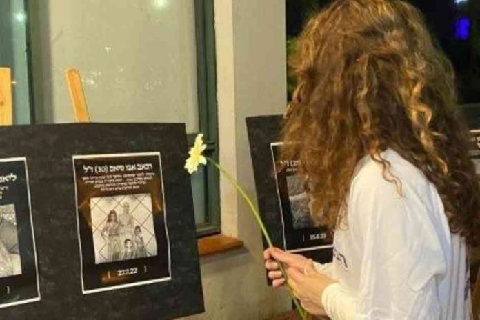 בתמונה: נערה מניחה פרח לצד תמונתה של אישה שנרצחה על-ידי בעלה.