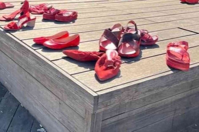 בתמונה: מיצג של עשרות זוגות נעליים אדומות - כחלק ממסר לעורר המודעות לאלימות נגד נשים.